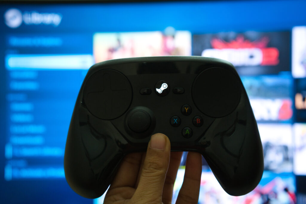 A person enjoying their favorite Steam video game while holding a game controller in front of a TV screen.