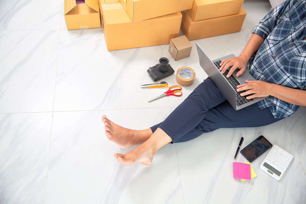 Woman taking orders of customers products by typing information on keyboard laptop in home office